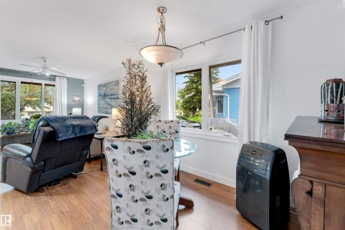 Wood-finish flooring throughout, featuring a multi-pane window, and a ceiling-mounted lighting fixture - 6008 37 Avenue Nw, Edmonton, AB - Indoor