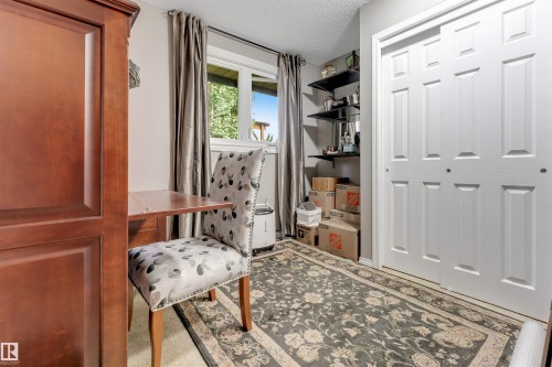 Bi-fold panel doors, built-in shelving, and a window with exterior visibility - 6008 37 Avenue Nw, Edmonton, AB - Indoor Photo Showing Other Room