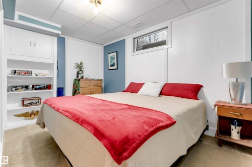 Built-in shelving with integrated cabinetry, paneled wall finishes, and a drop ceiling - 6008 37 Avenue Nw, Edmonton, AB - Indoor Photo Showing Bedroom