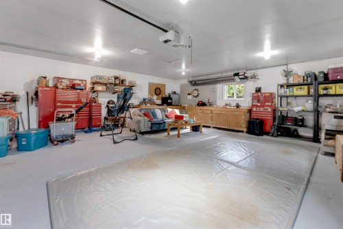 Spacious garage with light gray flooring, white walls, and built-in wood cabinetry - 6008 37 Avenue Nw, Edmonton, AB - Indoor Photo Showing Garage