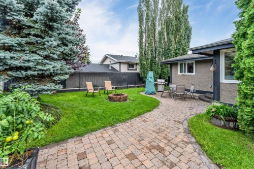 Expansive backyard featuring a paver patio, brick fire pit, and a paver pathway - 6008 37 Avenue Nw, Edmonton, AB - Outdoor