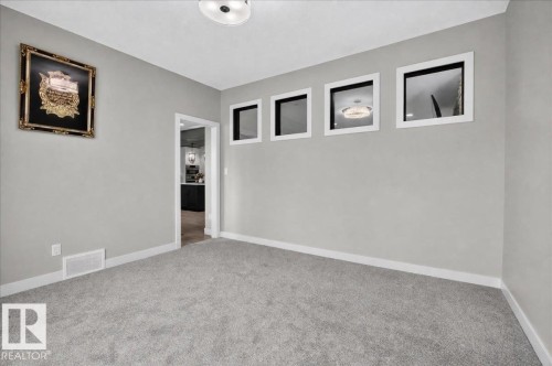 Plush carpeting, light gray walls, white trim, and square wall cutouts - 6813 Knox Loop Sw, Edmonton, AB - Indoor Photo Showing Other Room