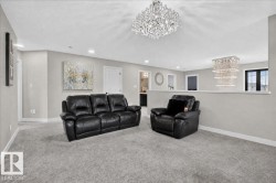 Recessed lighting, two crystal chandeliers, light gray carpeting, light gray walls, and white trim - 
