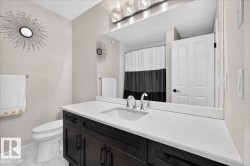 Floating vanity with dark wood-finish cabinetry, white stone countertop, undermount sink, and polished chrome faucet - 