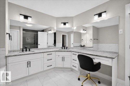 Corner vanity with dual sinks, granite countertops, white cabinetry, and matte black fixtures - 6813 Knox Loop Sw, Edmonton, AB - Indoor Photo Showing Bathroom
