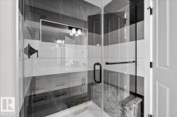 Glass-enclosed shower with horizontal striped tiling, a built-in stone bench, and matte black hardware - 
