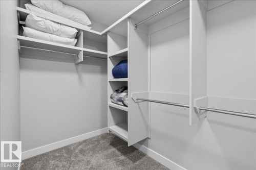 Custom built-in closet system featuring multiple shelving units and hanging rods - 6813 Knox Loop Sw, Edmonton, AB - Indoor With Storage