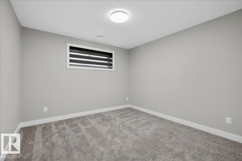 Neutral-toned walls with a single window, carpeted flooring, and a flush-mount ceiling light - 6813 Knox Loop Sw, Edmonton, AB - Indoor Photo Showing Other Room
