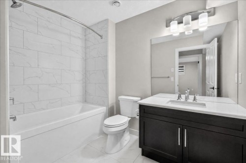 Modern bathroom featuring a single vanity with dark wood-finish cabinetry, a white countertop, and an undermount sink - 6813 Knox Loop Sw, Edmonton, AB - Indoor Photo Showing Bathroom