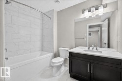 Modern bathroom featuring a single vanity with dark wood-finish cabinetry, a white countertop, and an undermount sink - 