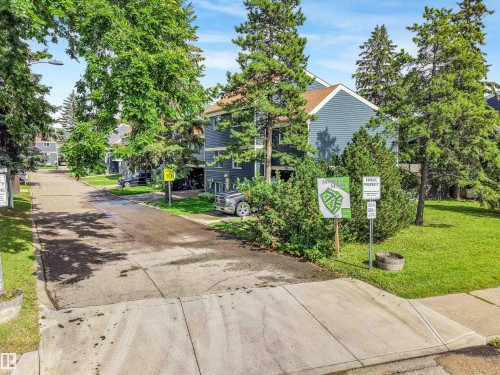 Blue siding exterior with multiple trees and shrubs - 120 Morin Maze Nw, Edmonton, AB - Outdoor