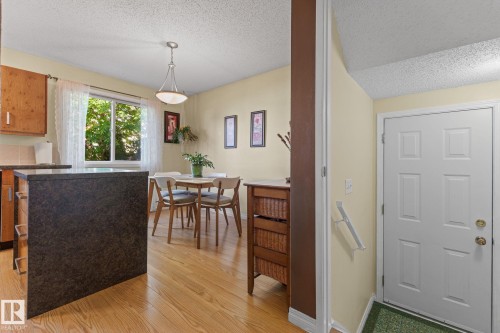 Hardwood flooring, window with natural light, panel door, pendant lighting, built-in kitchen island with countertop - 17132 103 Street Nw, Edmonton, AB 