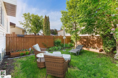 Expansive backyard featuring a manicured lawn, established privacy fencing, and mature trees - 17132 103 Street Nw, Edmonton, AB 