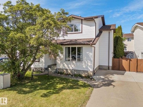 White siding exterior with brown trim, brown shingle roof, paved driveway, and mature landscaping - 17132 103 Street Nw, Edmonton, AB 