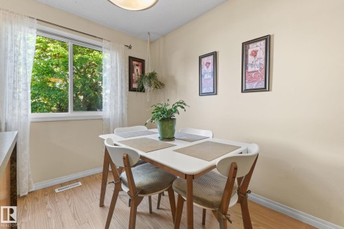 Bright interior with wood-finish flooring, a large window, a built-in light fixture, and light-toned walls - 17132 103 Street Nw, Edmonton, AB 