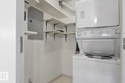 Stackable washer and dryer, white shelving units, and tile flooring - #102 6710 158 Av Nw, Edmonton, AB 