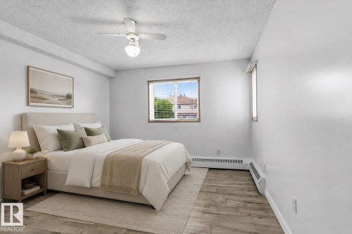 Wood-finish flooring, white walls, and a ceiling fan with integrated lighting - #102 6710 158 Av Nw, Edmonton, AB 