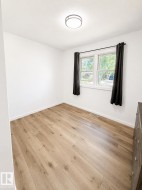Room featuring light wood-finish flooring, white baseboards, and bright white walls - 