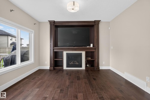 Built-in entertainment center with a fireplace and display shelving - 7014 Chivers Loop Sw, Edmonton, AB 