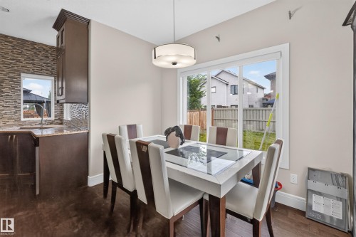Wood-finish flooring with a modern drum pendant light - 7014 Chivers Loop Sw, Edmonton, AB 