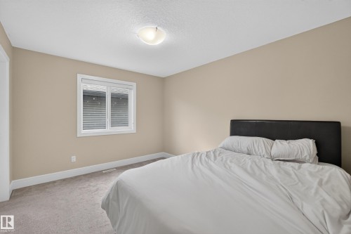 Neutral wall paint, white trim, recessed window with horizontal blinds, overhead flush-mount lighting, and carpeted flooring - 7014 Chivers Loop Sw, Edmonton, AB 