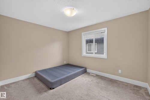 Neutral-toned walls complement the light-colored carpet flooring - 7014 Chivers Loop Sw, Edmonton, AB 