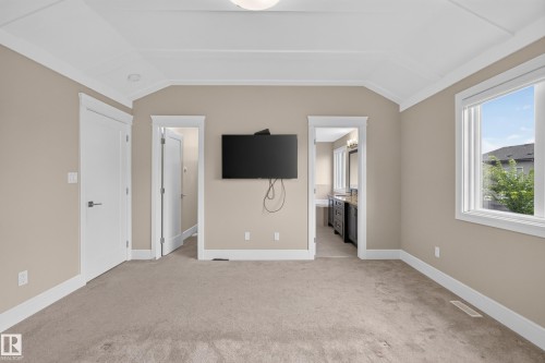 Tray ceiling, neutral wall tones, window with white trim, white doors, and carpeting - 7014 Chivers Loop Sw, Edmonton, AB 