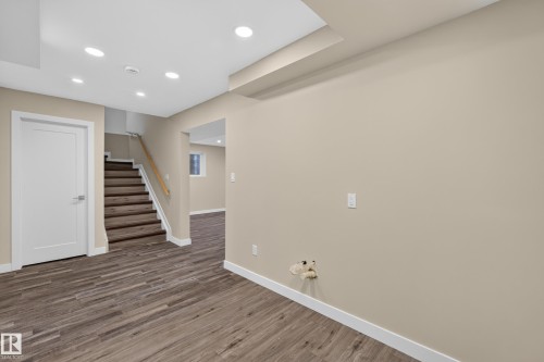 Recessed ceiling lighting, wood-finish flooring, white interior doors, wood handrail, and neutral wall tones - 7014 Chivers Loop Sw, Edmonton, AB 