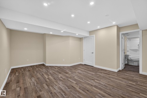 Recessed lighting illuminates the wood-finish flooring in this expansive room - 7014 Chivers Loop Sw, Edmonton, AB 