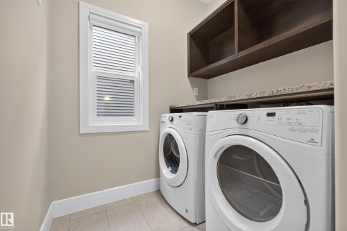 White-framed window with blinds, tile flooring, built-in shelving, and countertop space - 7014 Chivers Loop Sw, Edmonton, AB 