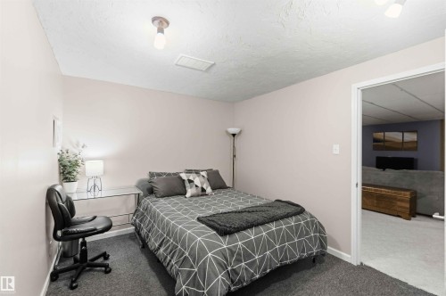 Plastered ceiling and light-colored walls in this carpeted room - 5208 105 Street Nw, Edmonton, AB - Indoor Photo Showing Bedroom