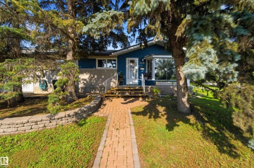 Front exterior featuring blue siding, white trim, a bay window, and a white entry door - 5208 105 Street Nw, Edmonton, AB - Outdoor