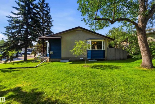 Single-story residence featuring a stucco exterior with blue siding accents - 5208 105 Street Nw, Edmonton, AB - Outdoor