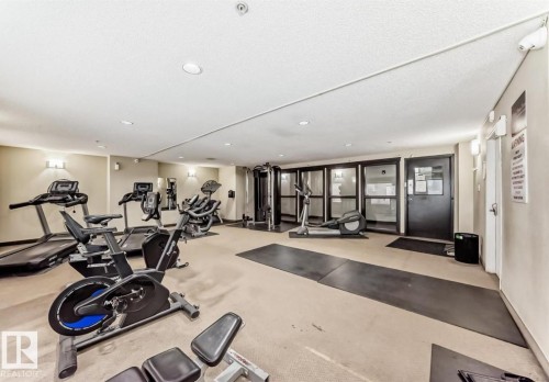 Fitness room featuring cardio machines, strength training equipment, and wall-mounted lighting - #1418 330 Clareview Station Dr Nw, Edmonton, AB - Indoor Photo Showing Gym Room