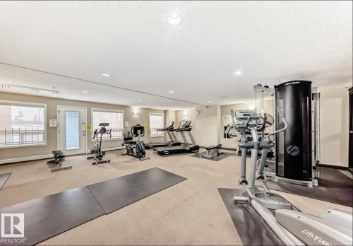 Fitness area with multiple windows, recessed lighting, and wall-mounted sconces - #1418 330 Clareview Station Dr Nw, Edmonton, AB - Indoor Photo Showing Gym Room