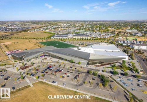 Expansive community center featuring modern architectural design, multiple sports fields, and extensive parking facilities - #1418 330 Clareview Station Dr Nw, Edmonton, AB - Outdoor With View