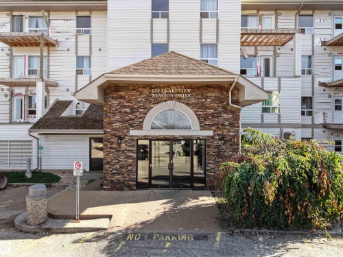 Stone veneer entryway with arched detailing and glass double doors - #1418 330 Clareview Station Dr Nw, Edmonton, AB - Outdoor With Balcony