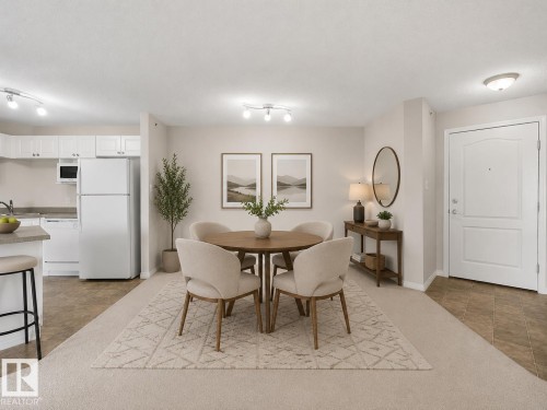 Recessed lighting, wood-finish flooring, white paneled door, built-in kitchen cabinetry, track lighting - #1418 330 Clareview Station Dr Nw, Edmonton, AB - Indoor Photo Showing Other Room