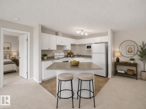 Kitchen with white cabinetry, white appliances, and a light-toned countertop - #1418 330 Clareview Station Dr Nw, Edmonton, AB - Indoor Photo Showing Kitchen