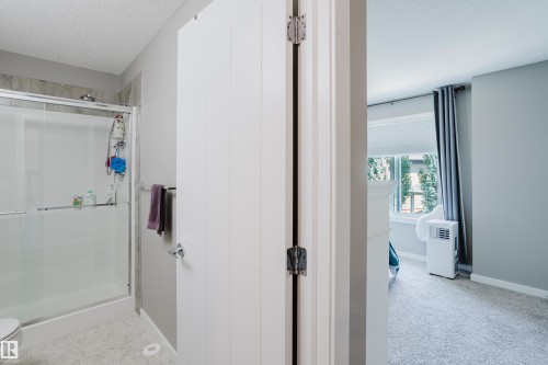 Bathroom featuring a glass-enclosed shower with subway tile surround, neutral wall paint, and white trim - #28 2215 24 St Nw, Edmonton, AB - Indoor