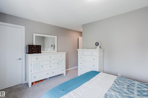 Neutral grey wall color with white trim and a white paneled door - #28 2215 24 St Nw, Edmonton, AB - Indoor Photo Showing Bedroom