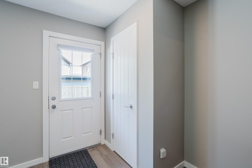 Entryway featuring a white paneled door with an integrated multi-pane window and brushed nickel hardware - #28 2215 24 St Nw, Edmonton, AB - Indoor Photo Showing Other Room