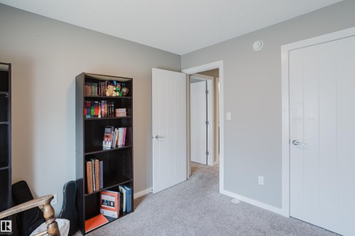 Neutral gray wall paint with white trim, gray carpet flooring, and white interior doors with contemporary hardware - #28 2215 24 St Nw, Edmonton, AB - Indoor