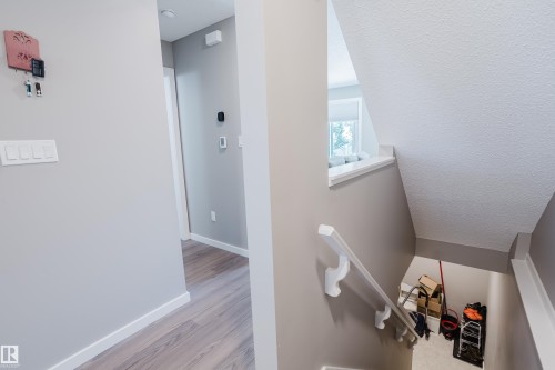 Hallway with wood-finish flooring, light grey walls, and white trim - #28 2215 24 St Nw, Edmonton, AB - Indoor Photo Showing Other Room