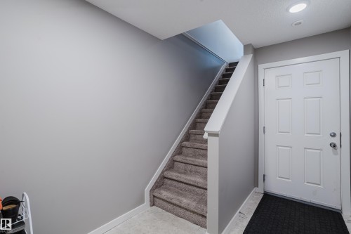 Carpeted staircase with white trim, leading to an upper level - #28 2215 24 St Nw, Edmonton, AB - Indoor Photo Showing Other Room