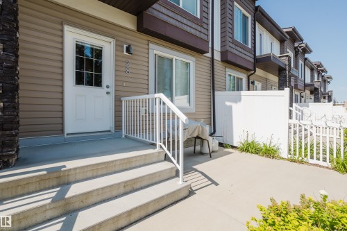 Entryway featuring a white door with divided lites, concrete steps, and a white railing - #28 2215 24 St Nw, Edmonton, AB - Outdoor With Exterior