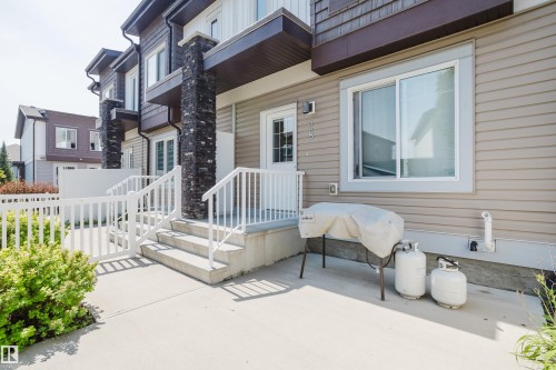 Exterior patio with concrete surface, white railing, and multi-level concrete steps - #28 2215 24 St Nw, Edmonton, AB - Outdoor With Exterior