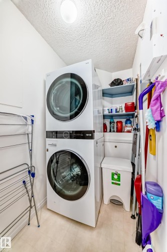 Stackable washer and dryer, built-in corner shelving, overhead lighting, and light-toned flooring - #108 12028 103 Av Nw, Edmonton, AB 