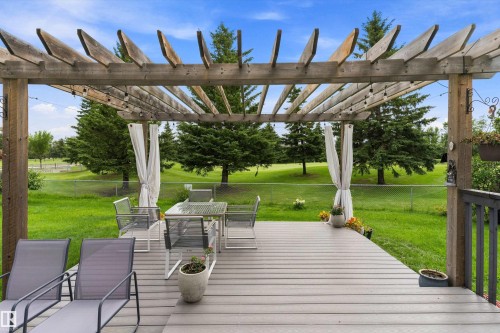 Expansive outdoor deck with a wood pergola, composite decking, and a privacy curtain - 20845 92A Avenue Nw, Edmonton, AB - Outdoor With Exterior