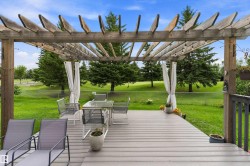 Expansive outdoor deck with a wood pergola, composite decking, and a privacy curtain - 